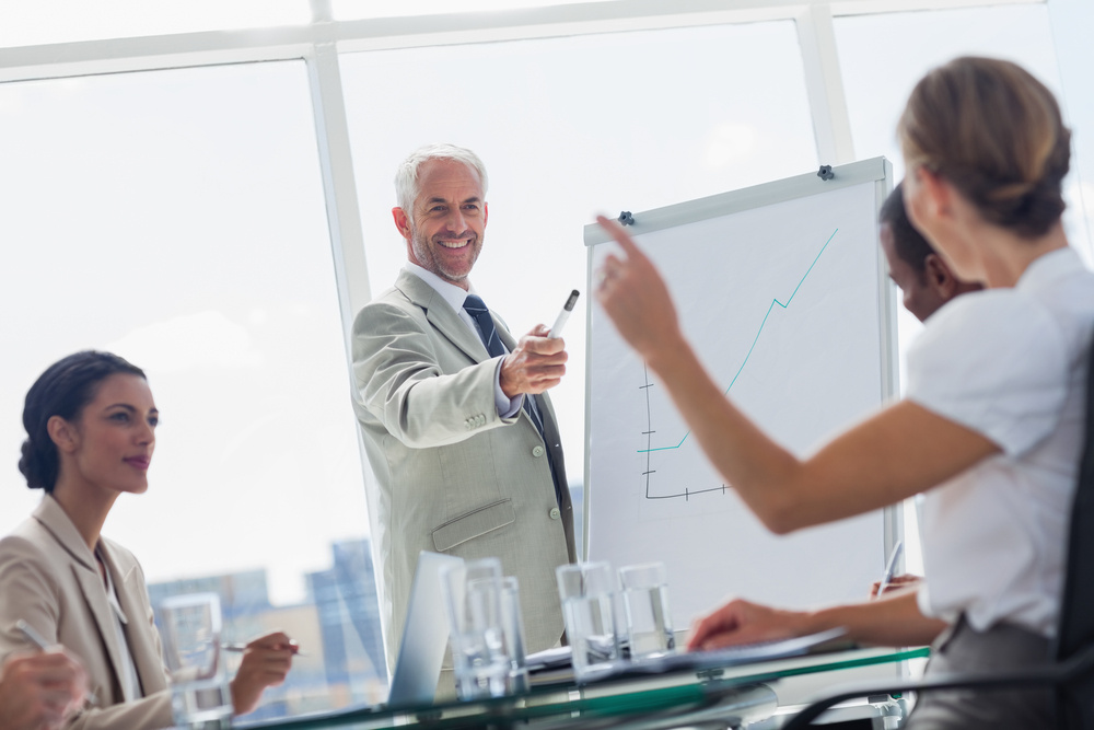 Cheerful boss pointing at a colleague during a meeting