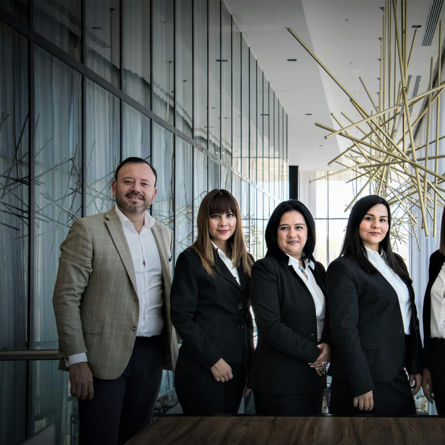 Diverse business team in formal attire posed in modern office.
