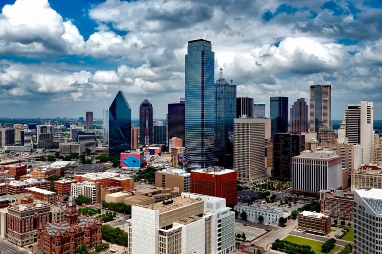 A stunning panoramic view of the Dallas skyline under dramatic clouds, capturing the city's iconic skyscrapers.